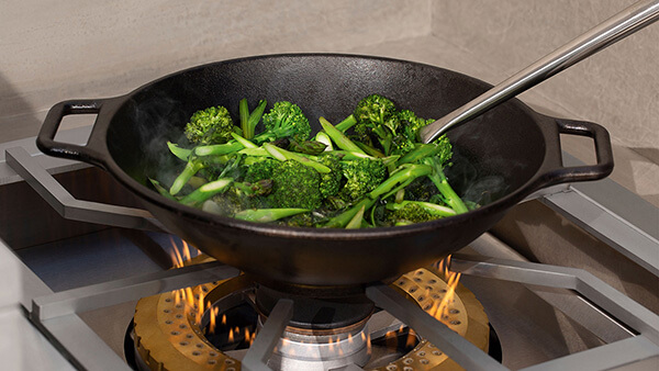 Vegetables being wok-cooked atop of a DCS Power Burner