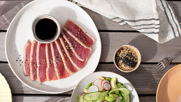 Top view of meat, seeds and vegetables served in dishes on a table